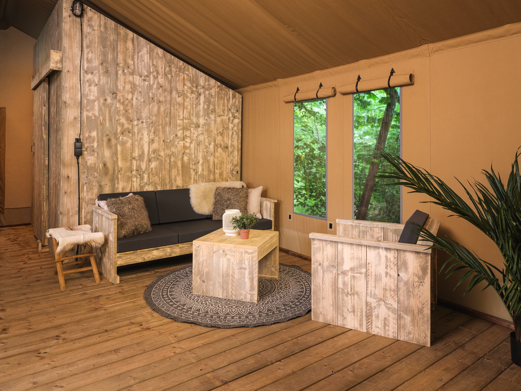 Interior de una tienda safari: sala con sofá, madera y lona cálida